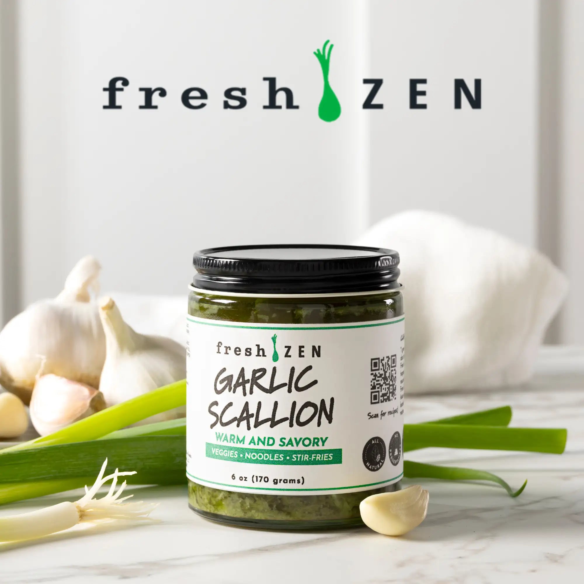 A glass jar of fresh zen garlic scallion sauce with a black lid and white label, filled with green pesto-like contents.